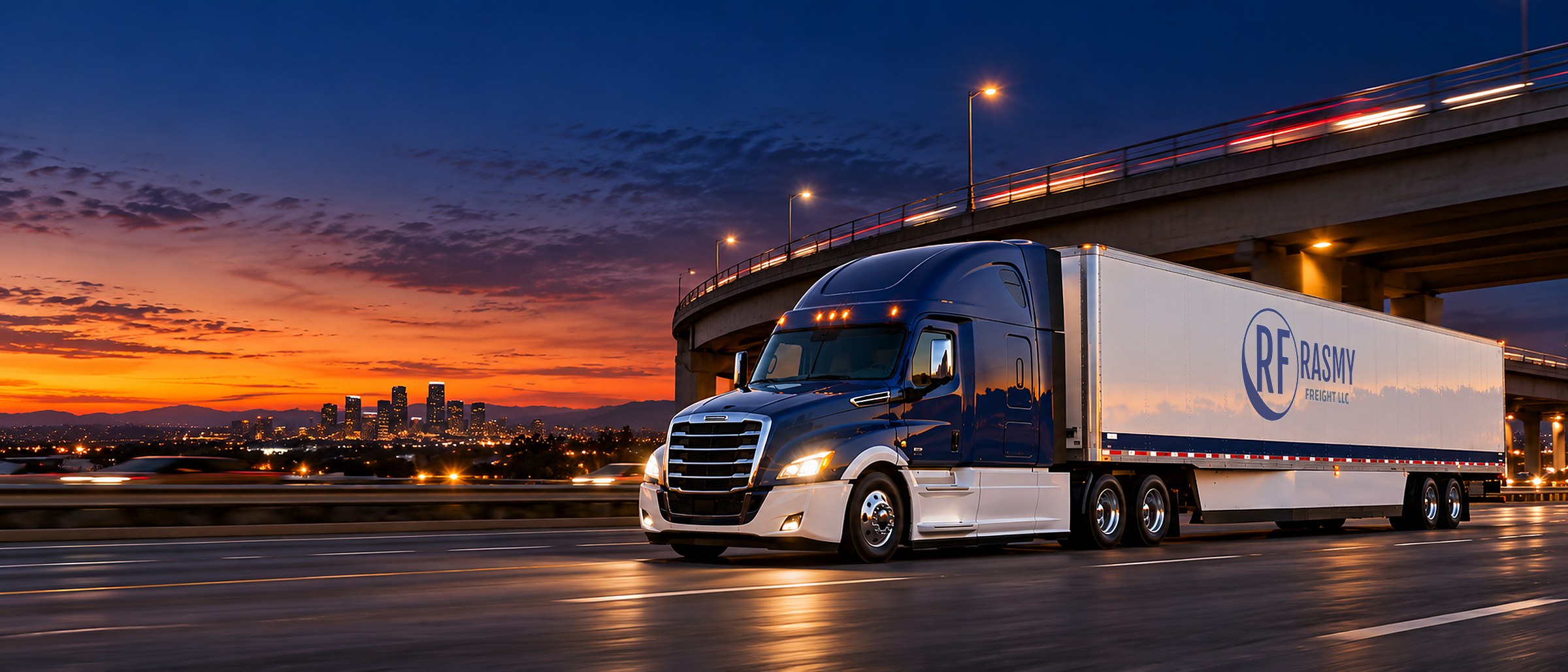 Rasmy Freight tractor-trailer heading down the interstate under an overpass at dusk